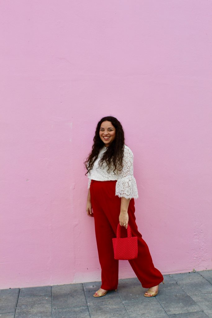wearing white lace blouse from H&M, red trousers, pink Zara purse, and nude heels