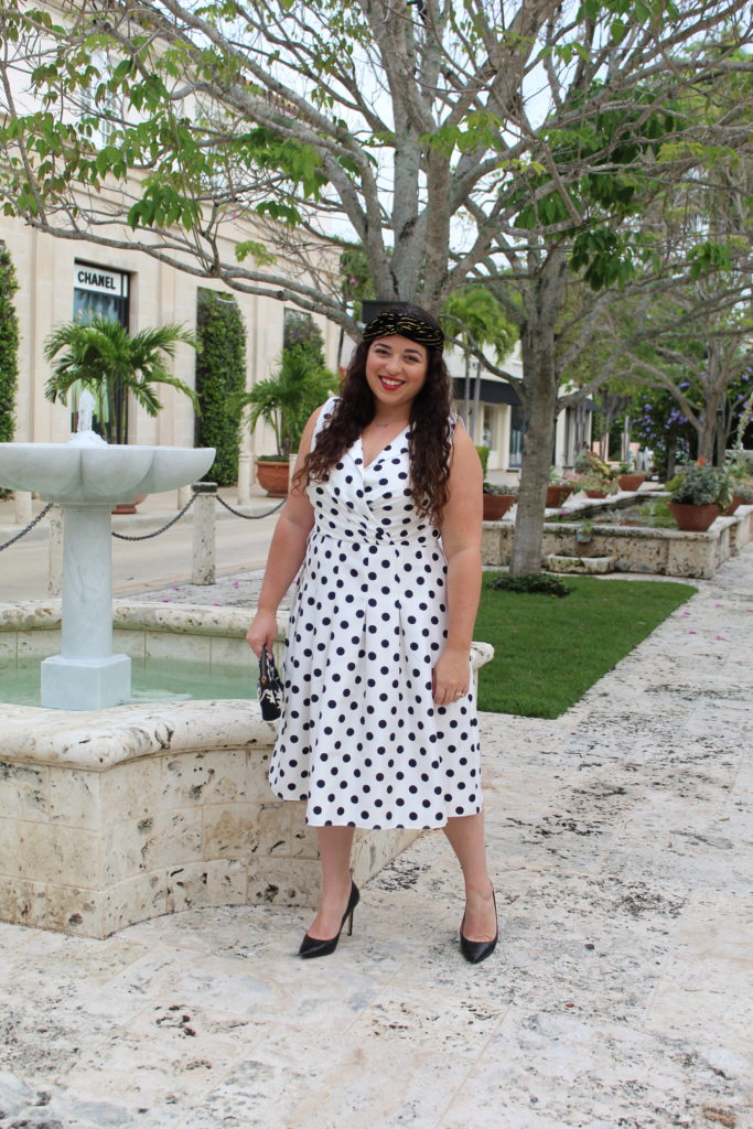 wearing white with black polka dot fit and flare dress with black Sam Edelman pumps and Zara headband.