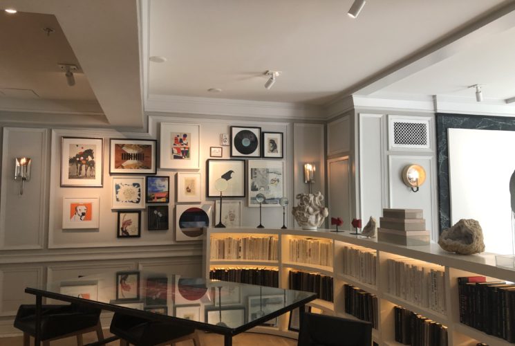 Book shelves and gallery wall inside the Kimpton Brice Hotel checkin